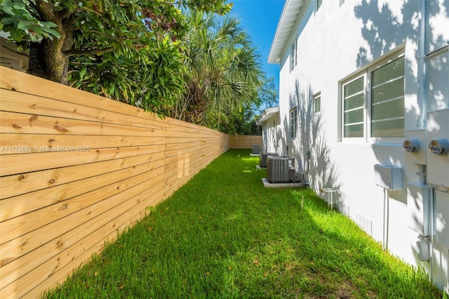 view of yard with central AC and a fenced backyard