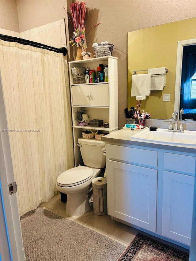 bathroom with tile patterned flooring, vanity, curtained shower, and toilet