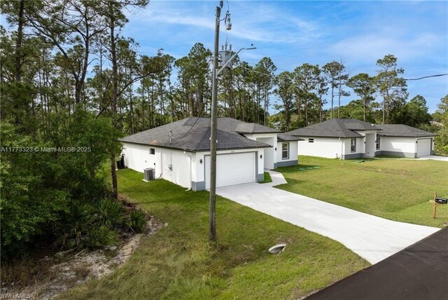 view of front of property with central air condition unit, an attached garage, concrete driveway, a front lawn, and stucco siding