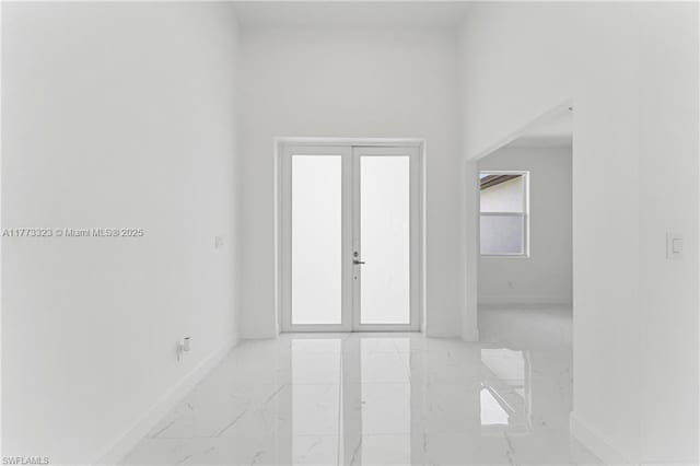 foyer with baseboards and marble finish floor