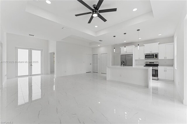 unfurnished living room featuring visible vents, ceiling fan, recessed lighting, a tray ceiling, and french doors