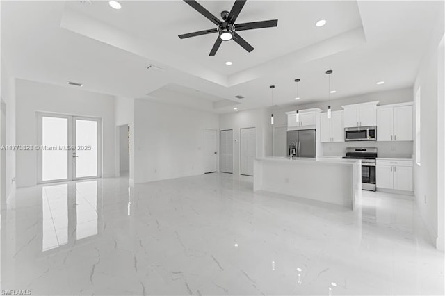 unfurnished living room with a tray ceiling, french doors, a ceiling fan, visible vents, and recessed lighting