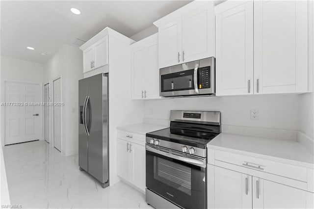kitchen with white cabinets, marble finish floor, stainless steel appliances, and recessed lighting