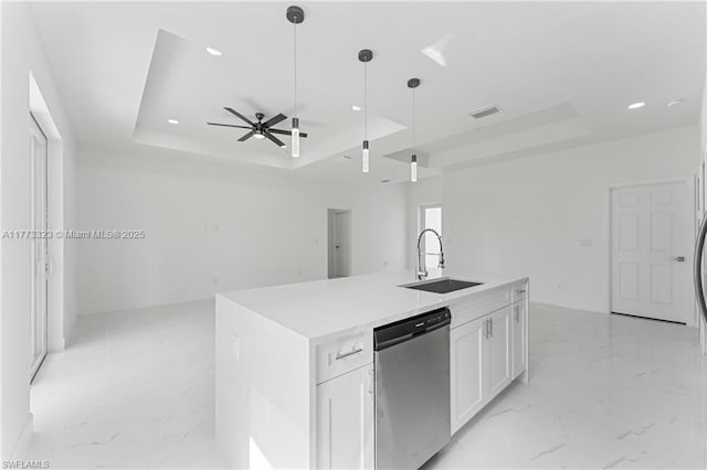 kitchen with marble finish floor, a sink, a tray ceiling, and stainless steel dishwasher