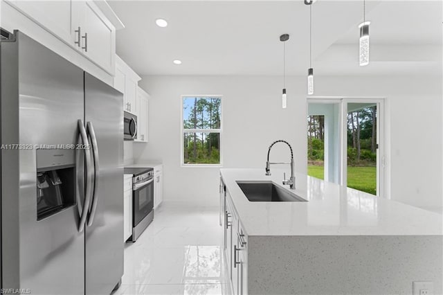 kitchen featuring marble finish floor, stainless steel appliances, a center island with sink, white cabinetry, and a sink