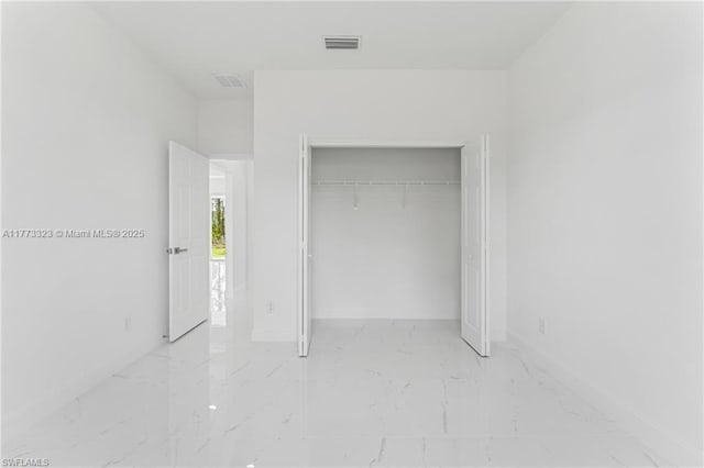 unfurnished bedroom with marble finish floor, baseboards, visible vents, and a closet