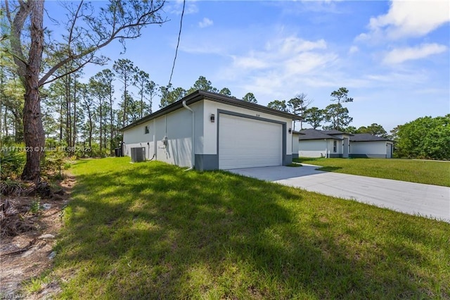 view of side of home featuring concrete driveway, stucco siding, central air condition unit, an attached garage, and a yard