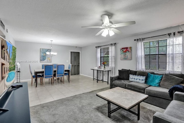 living room with light carpet, a textured ceiling, baseboards, light tile patterned floors, and ceiling fan with notable chandelier