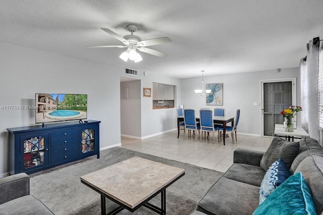 living area with a textured ceiling, visible vents, baseboards, ceiling fan with notable chandelier, and tile patterned flooring