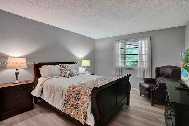 bedroom featuring light wood-style floors and a textured ceiling