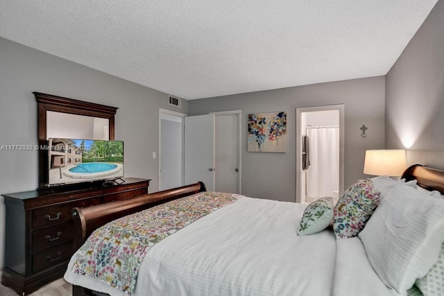 bedroom with a textured ceiling and visible vents