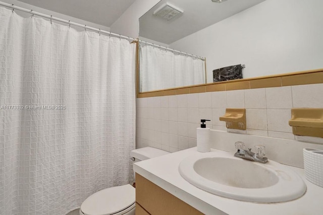 bathroom featuring tile walls, visible vents, toilet, and vanity