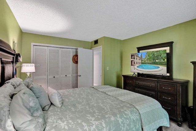 bedroom featuring visible vents, a closet, and a textured ceiling