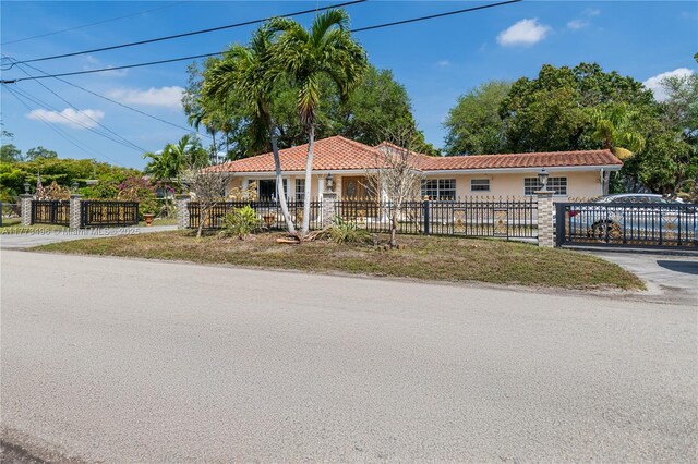 85 NW 165th St, Miami, FL 33169 - view of front of house featuring a tile roof, a fenced front yard, and stucco siding