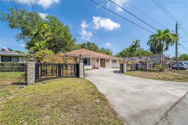 85 NW 165th St, Miami, FL 33169 - view of front of home with driveway, a tile roof, a fenced front yard, and a front yard