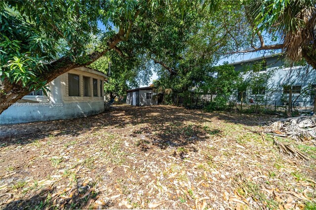 85 NW 165th St, Miami, FL 33169 - view of yard with an outdoor structure, a storage unit, and fence