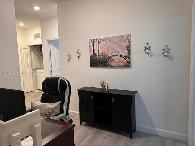 office area featuring light wood finished floors, baseboards, and visible vents