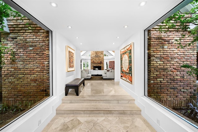 9000 Arvida Dr, Coral Gables, FL 33156 - corridor with marble finish floor, baseboards, brick wall, and recessed lighting