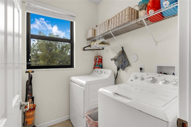 washroom with baseboards, independent washer and dryer, and laundry area
