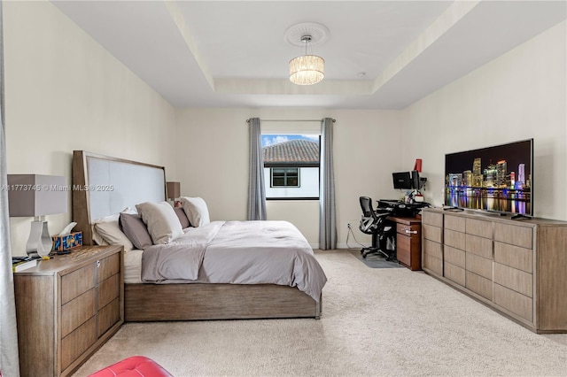 bedroom with a tray ceiling and light colored carpet