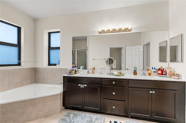 bathroom featuring a shower stall, double vanity, a sink, a garden tub, and tile patterned flooring