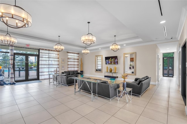 living area with a tray ceiling, ornamental molding, french doors, and light tile patterned floors