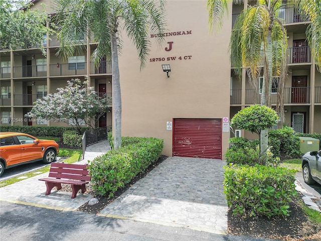 12750 SW 4th Ct Unit 407J, Pembroke Pines, FL 33027 - view of building exterior featuring an attached garage and driveway