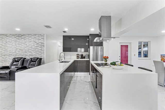 910 N 70th Ave, Hollywood, FL 33024 - kitchen featuring freestanding refrigerator, modern cabinets, light marble finish floors, island range hood, and a sink