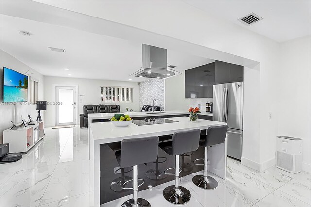 910 N 70th Ave, Hollywood, FL 33024 - kitchen with freestanding refrigerator, island range hood, modern cabinets, light countertops, and a breakfast bar