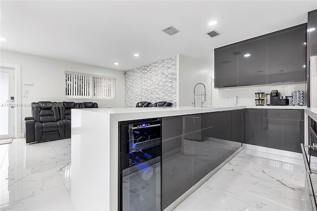 910 N 70th Ave, Hollywood, FL 33024 - kitchen with modern cabinets, beverage cooler, light marble finish flooring, light countertops, and recessed lighting