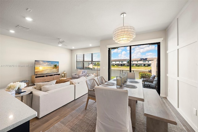 dining space with visible vents, wood finished floors, recessed lighting, and a textured ceiling