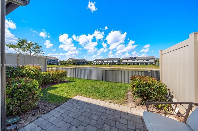 view of patio featuring a fenced backyard, a water view, and a residential view