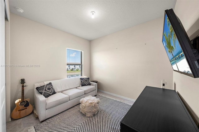 carpeted living area with baseboards and a textured ceiling