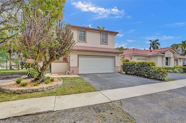 view of front of home with driveway, stucco siding, an attached garage, and a tiled roof