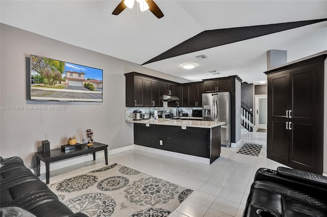 kitchen with light countertops, light tile patterned floors, stainless steel fridge with ice dispenser, ceiling fan, and a peninsula