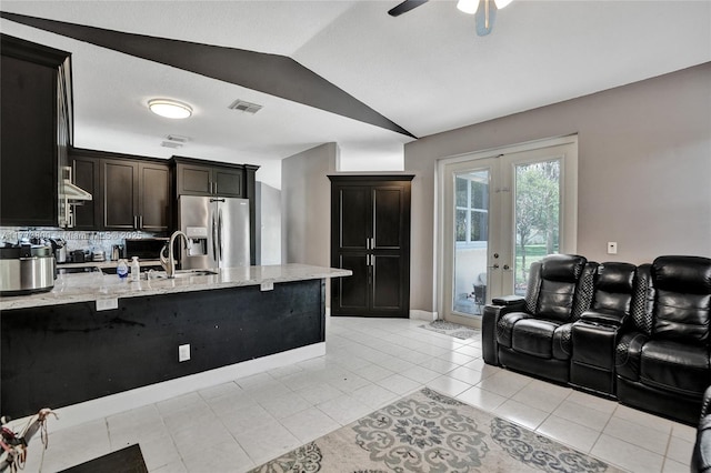 kitchen featuring vaulted ceiling, french doors, a sink, stainless steel refrigerator with ice dispenser, and visible vents