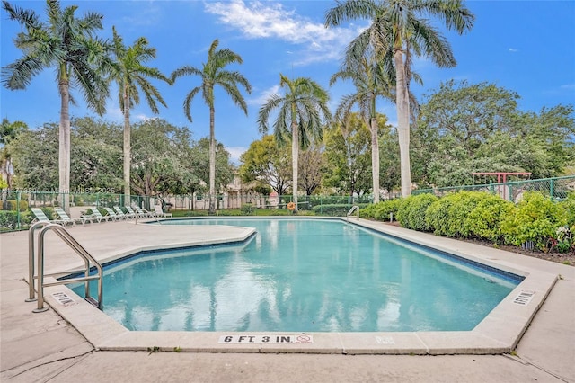 community pool with fence and a patio area