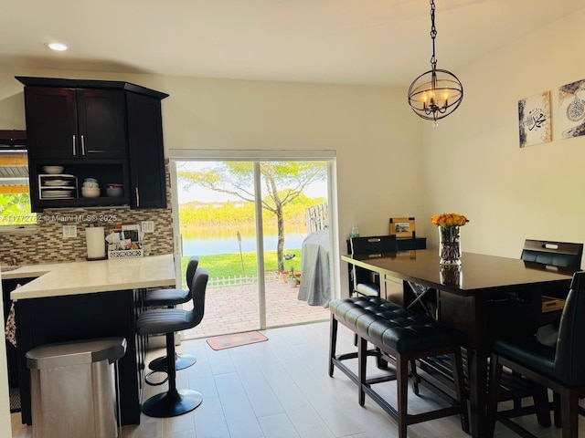 dining space with an inviting chandelier, a water view, and recessed lighting
