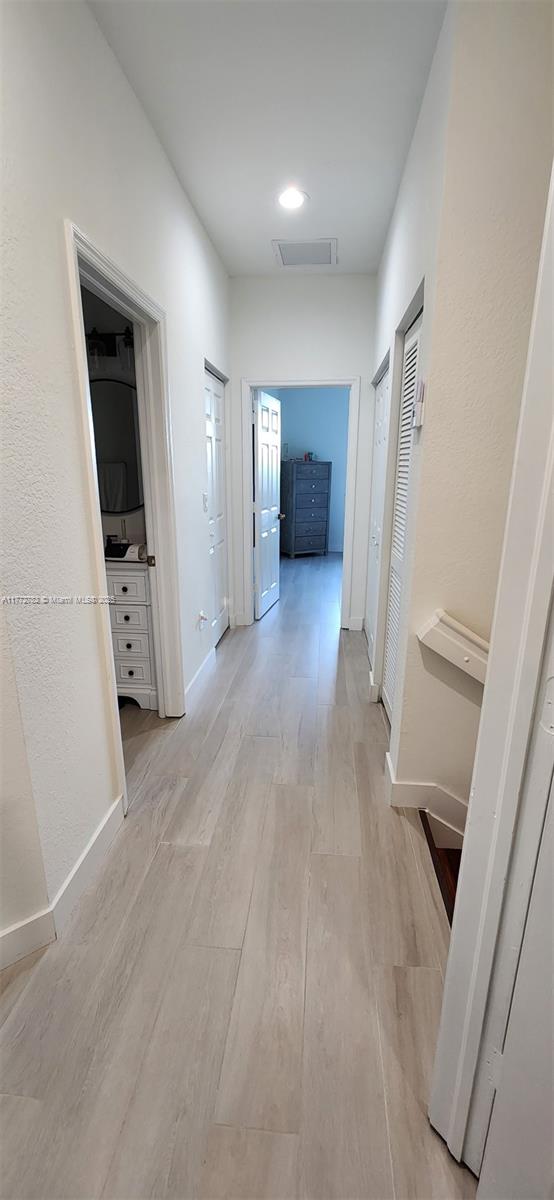 hall with baseboards and light wood-style flooring