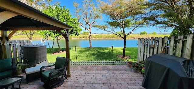 view of patio with cooling unit, fence, a water view, and a grill