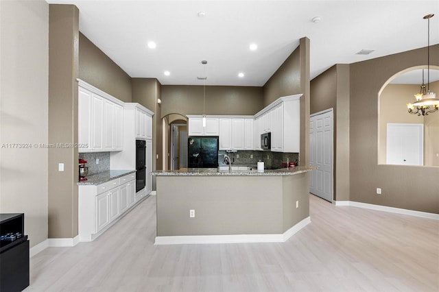 2031 SW 185th Ave, Miramar, FL 33029 - kitchen featuring black appliances, arched walkways, light wood finished floors, decorative backsplash, and recessed lighting