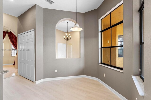 2031 SW 185th Ave, Miramar, FL 33029 - empty room featuring light wood-type flooring, a chandelier, and arched walkways
