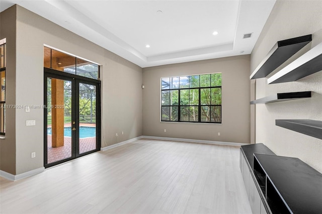 2031 SW 185th Ave, Miramar, FL 33029 - unfurnished living room featuring light wood-style floors, french doors, a raised ceiling, and recessed lighting