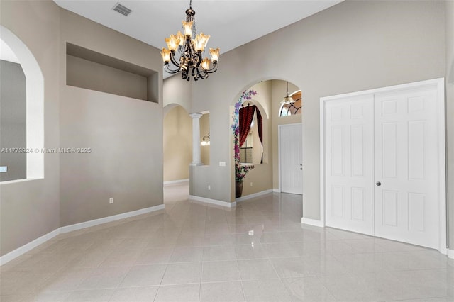 2031 SW 185th Ave, Miramar, FL 33029 - spare room with arched walkways, light tile patterned flooring, a chandelier, decorative columns, and a towering ceiling