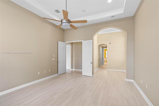 2031 SW 185th Ave, Miramar, FL 33029 - unfurnished bedroom featuring arched walkways, light wood-style floors, recessed lighting, a tray ceiling, and ceiling fan