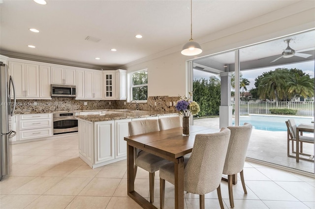 2426 Deer Creek Rd, Weston, FL 33327 - kitchen featuring decorative backsplash, light tile patterned floors, stone countertops, glass insert cabinets, and stainless steel appliances
