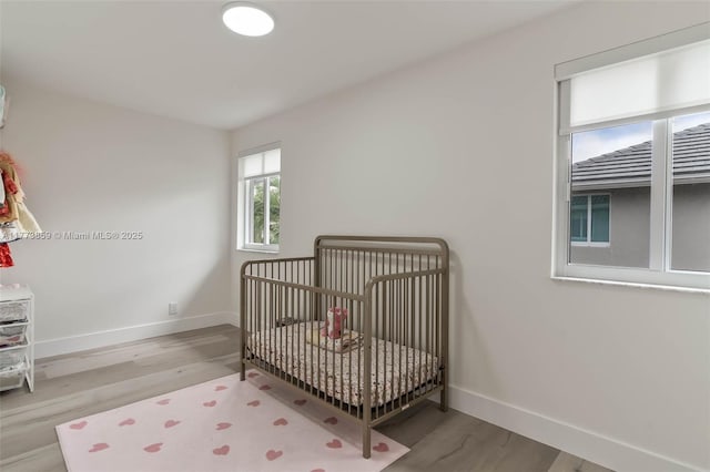 2426 Deer Creek Rd, Weston, FL 33327 - bedroom featuring baseboards, a crib, and wood finished floors