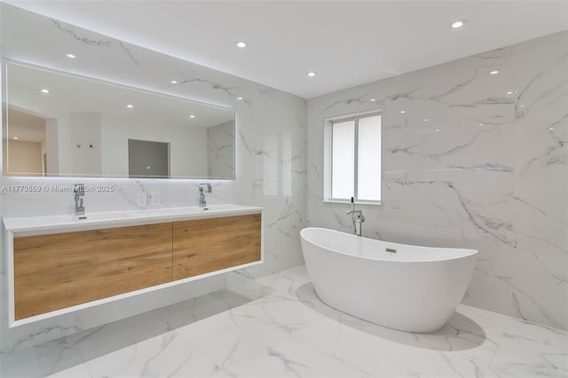 2426 Deer Creek Rd, Weston, FL 33327 - full bathroom featuring double vanity, marble finish floor, stone wall, recessed lighting, and a freestanding bath