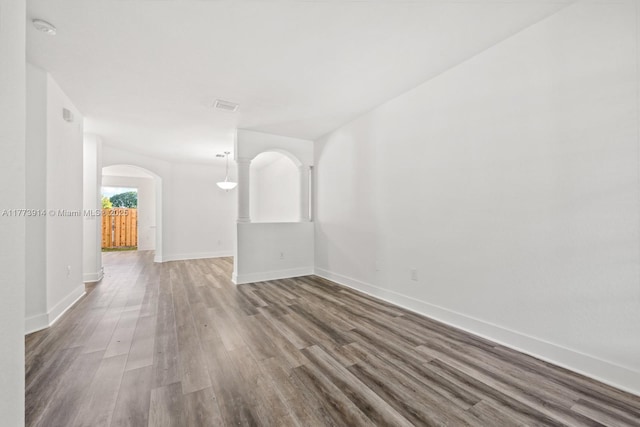 2556 SE 15th Ct, Homestead, FL 33035 - empty room featuring baseboards, visible vents, wood finished floors, and arched walkways