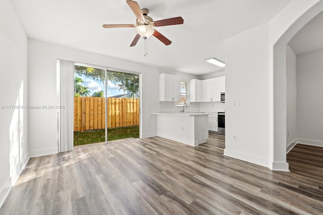 2556 SE 15th Ct, Homestead, FL 33035 - unfurnished living room with arched walkways, baseboards, wood finished floors, and a ceiling fan